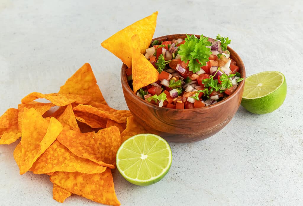 Mexican appetizer Pico de Gallo in a bowl and ingredients on the table. pico de gallo at esmeraldas the best mexican restaurant in eureka