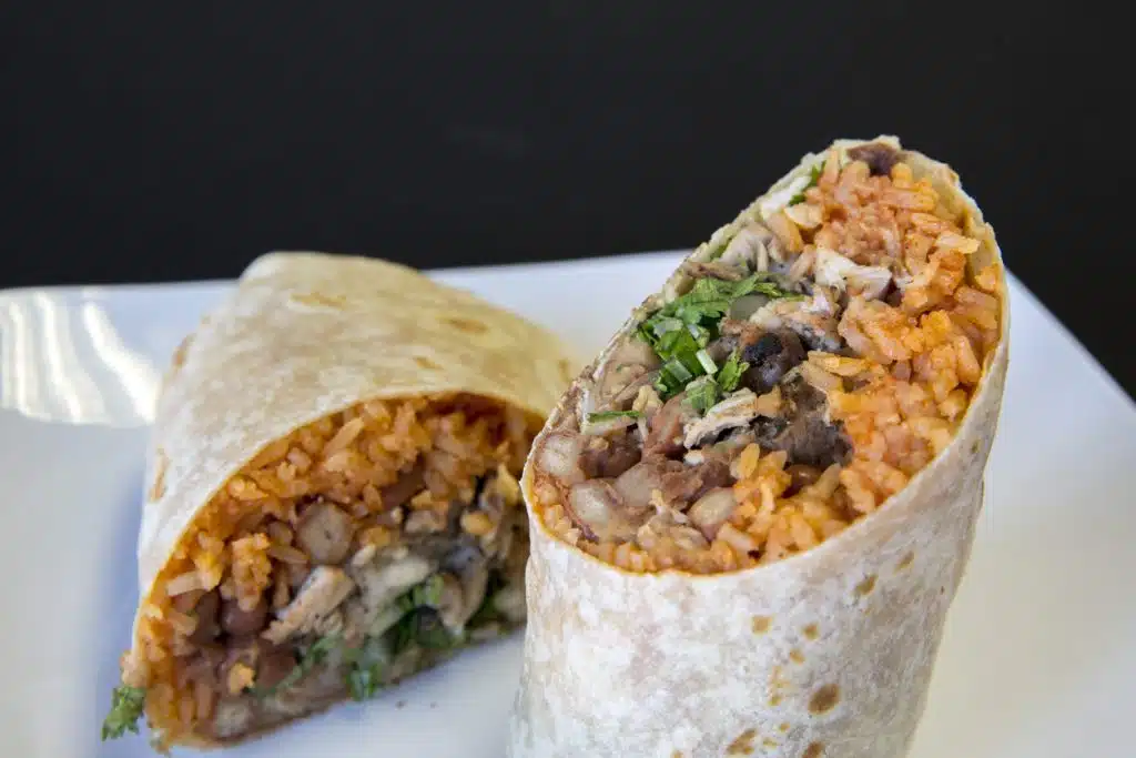A freshly made burrito cut in half at Esmeralda&rsquo;s 2.0 in Eureka, California, showing tender meat, melted cheese, and hand-rolled tortillas served with rice, beans, and salsa &mdash; authentic Mexican food made fresh for Humboldt County.
